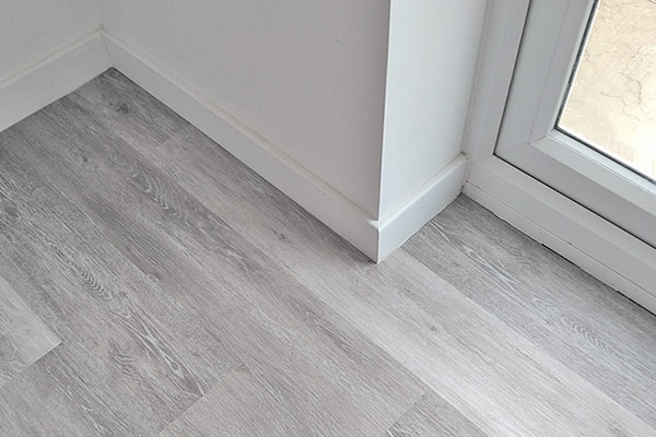 Replaced carpet with stylish grey laminate including removal and refitting of skirting boards